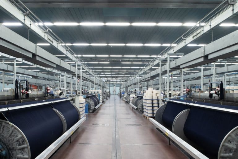 modern denim textile factory interior with industrial machines producing denim fabric at large scale.