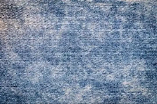 Acid wash denim fabric texture with faded blue vintage distressed effect