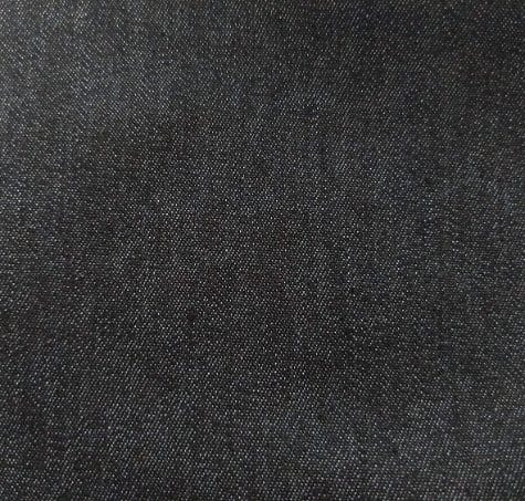 Black denim fabric close up showing dense cotton twill weave and smooth texture