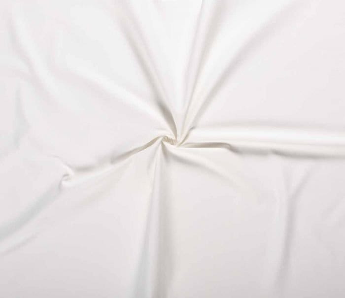 White denim fabric with smooth texture and heavy cotton twill construction