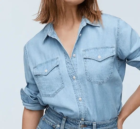 Woman wearing a light blue chambray shirt paired with denim jeans, demonstrating a casual and fashionable styling idea.