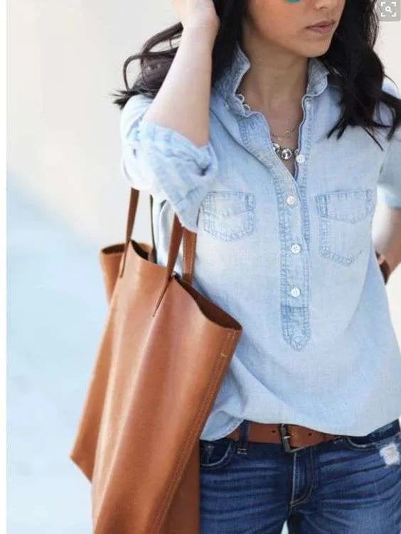 Fashionable woman wearing a light blue chambray blouse, showing that chambray remains a timeless wardrobe staple.