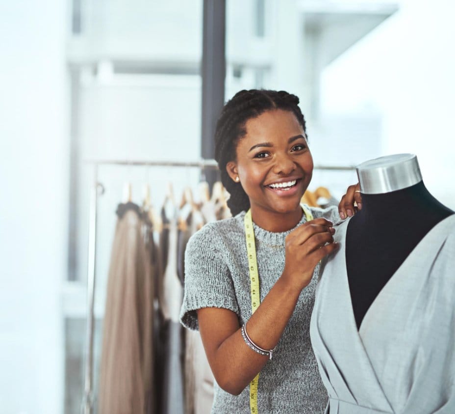 Fashion designer fitting a chambray garment on a dress form, highlighting chambray's popularity among sewists and garment makers.