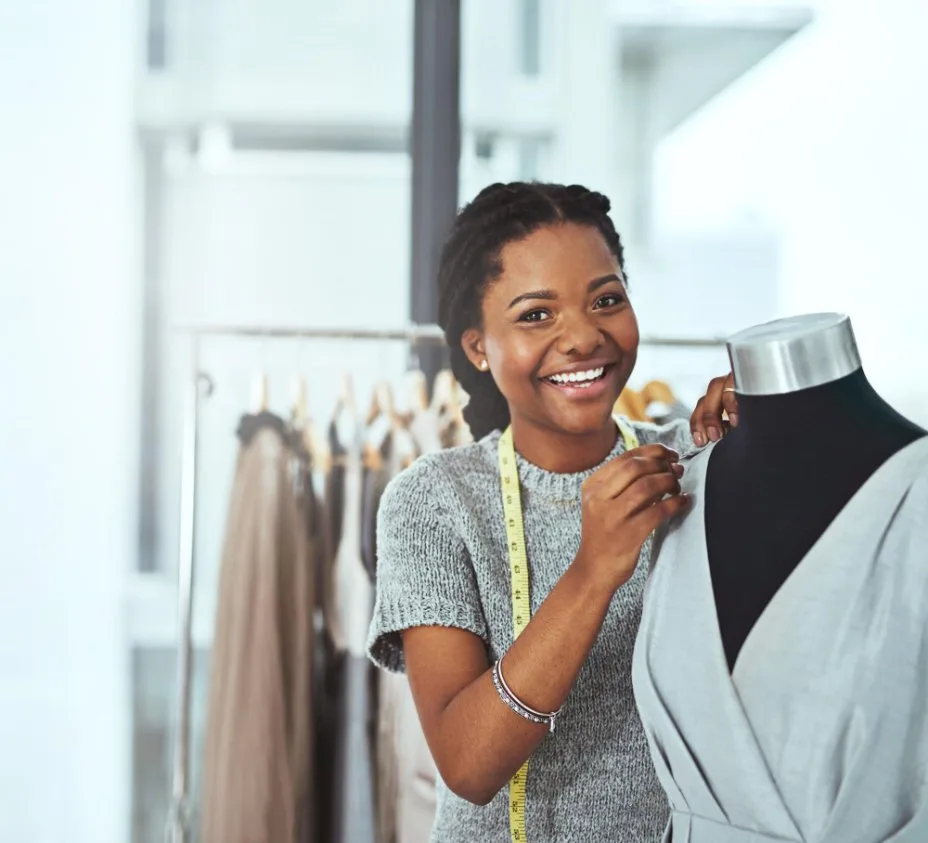 Fashion designer fitting a chambray garment on a dress form, highlighting chambray's popularity among sewists and garment makers.