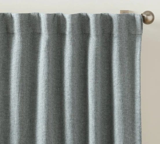 Grey chambray curtain hanging from a curtain pole, showing how chambray fabric can be used in home decor projects.