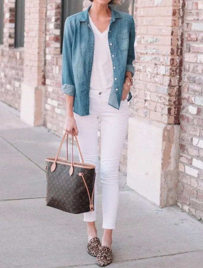 Woman wearing a chambray shirt with white pants and leopard print flats, showcasing footwear options that pair well with chambray.