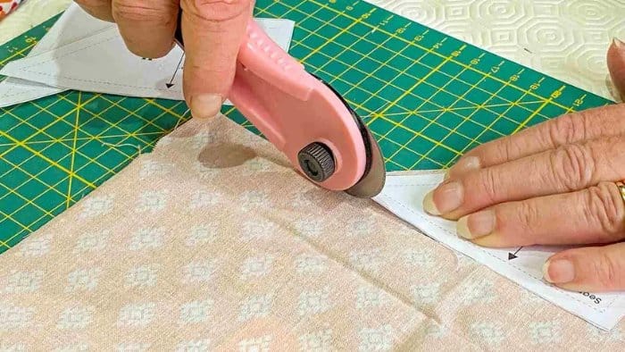 Rotary cutter trimming fabric on a cutting mat for precise nylon fabric cutting and sewing preparation.