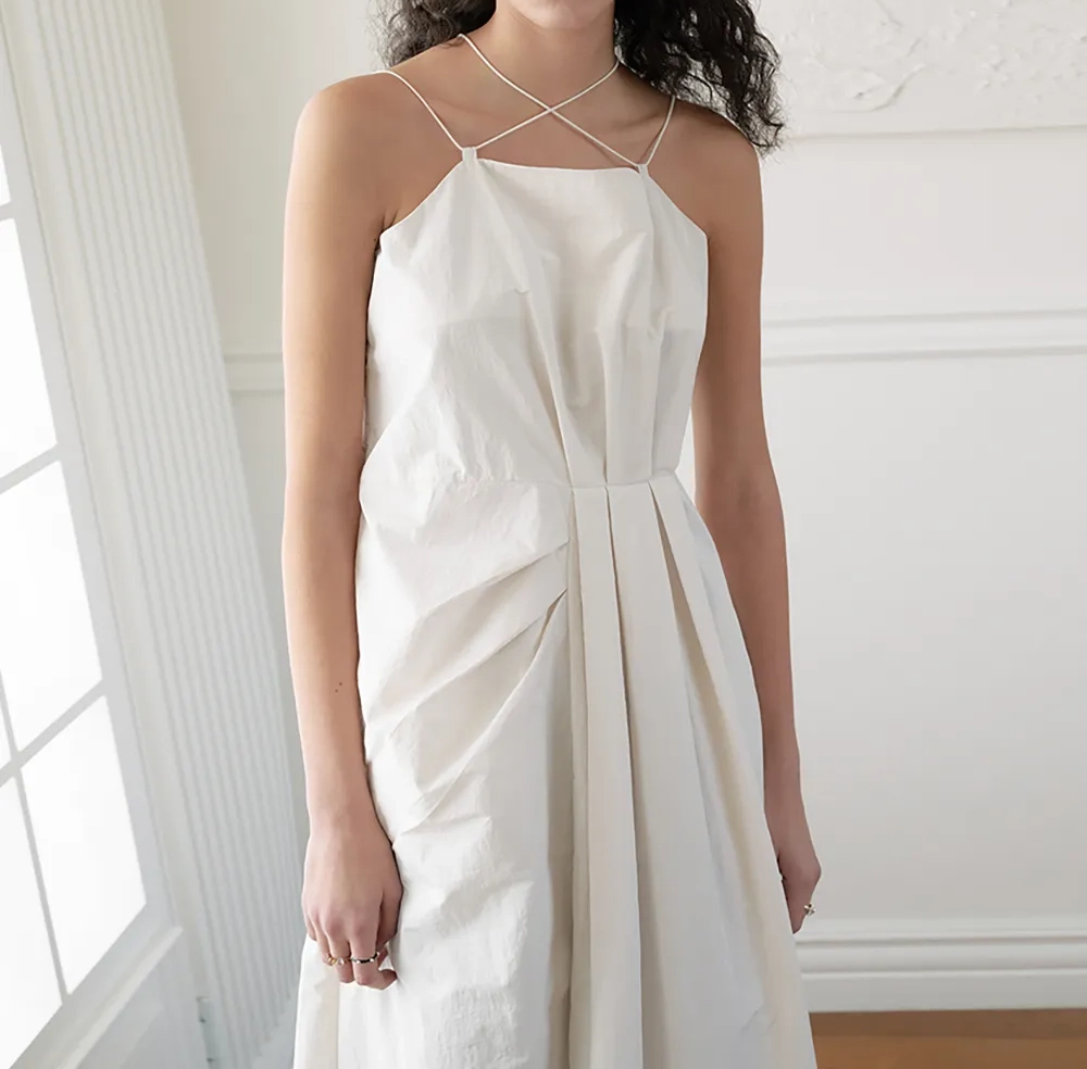 Elegant white nylon dress displaying soft draping, fluid movement and modern fashion styling.