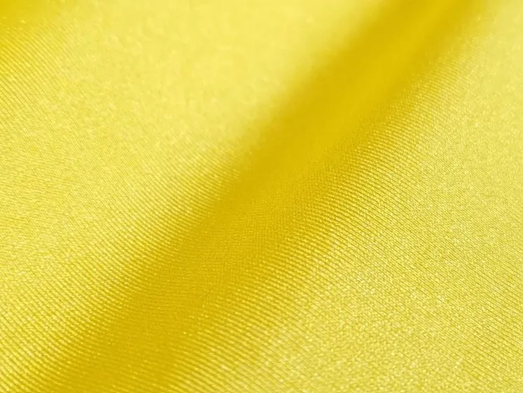 Close-up of bright yellow nylon fabric showcasing its smooth texture, lightweight construction and subtle sheen.