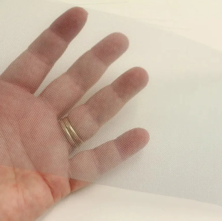 Transparent nylon mesh fabric stretched over a hand, showcasing its lightweight, breathable and flexible structure.