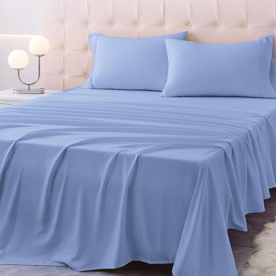 Light blue fitted bed sheets made with stretch fabric neatly arranged on a bed.